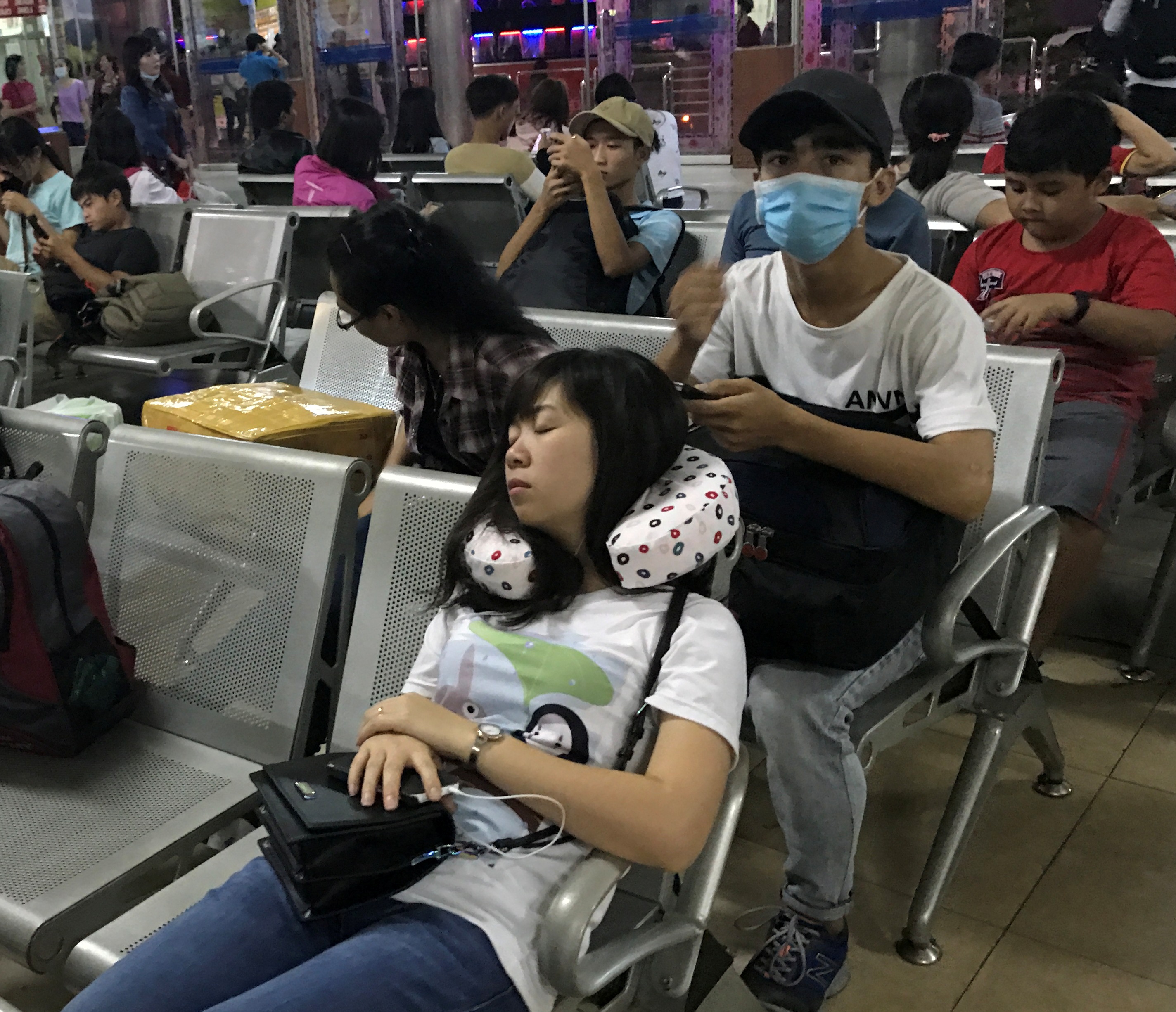 Một cô gái ngủ trên ghế trong lúc chờ xe