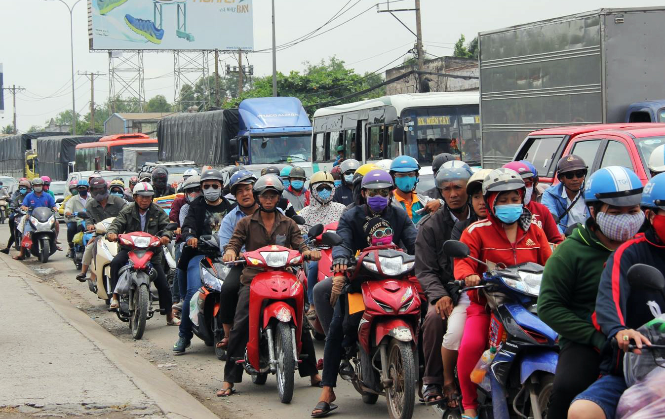 Tương tự, tr&ecirc;n quốc lộ 1, đ&ocirc;ng đảo người d&acirc;n cũng chen ch&uacute;c, tất bật về qu&ecirc; nghỉ lễ.