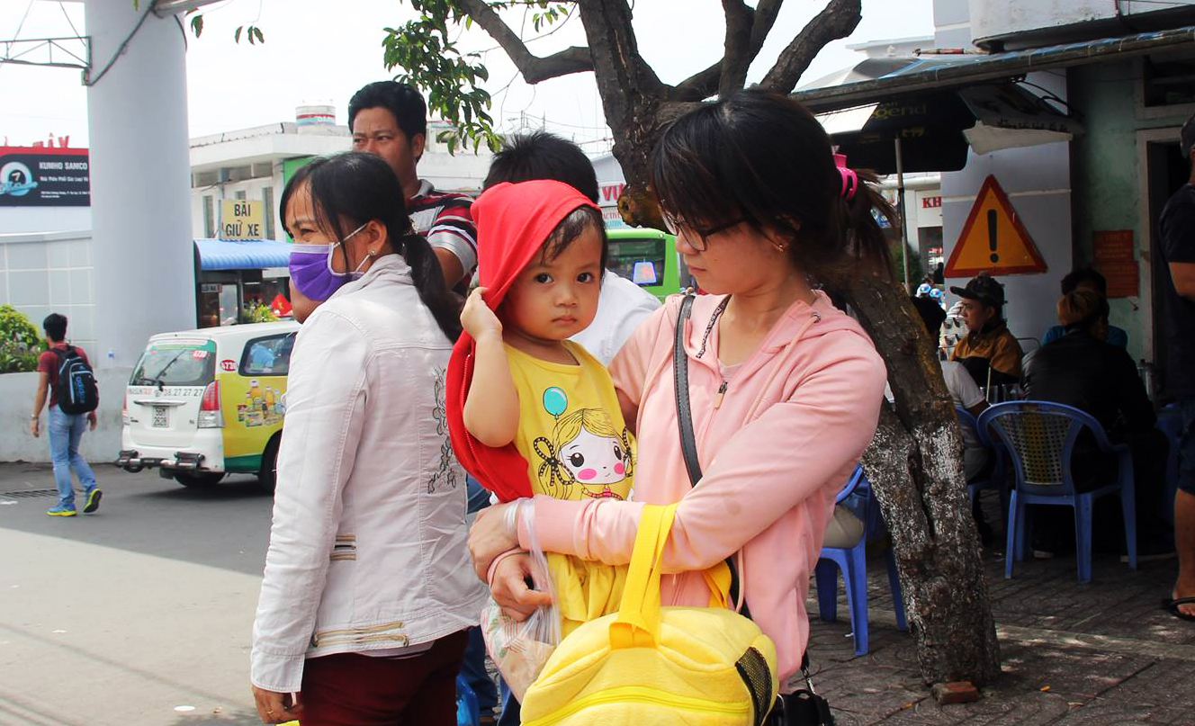Một em nhỏ mệt mỏi c&ugrave;ng mẹ chờ xe để về qu&ecirc;.