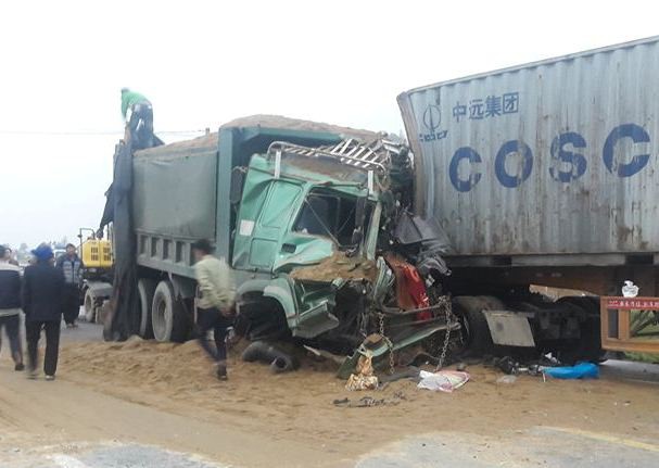 Xe tải đấu đầu xe container, 2 tài xế kẹt trong cabin bẹp dúm
