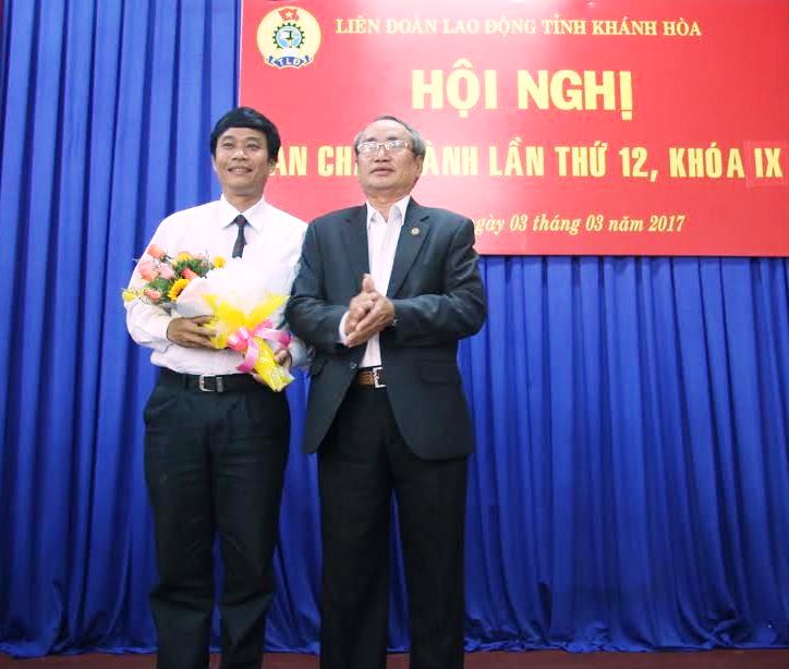 Ông Nguyễn Hoà, Chủ tịch LĐLĐ tỉnh Khánh Hoà (phải) tặng hoa chúc mừng ông Bùi Thanh Bình