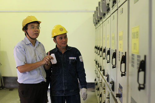 Anh Lê Duy Phúc (bìa trái) trong một trạm điện ứng dụng đề tài nghiên cứu khoa học của mình Ảnh: Hoàng Triều