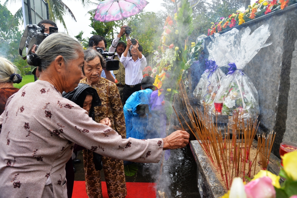 Người d&acirc;n đội mưa thắp hương tưởng niệm vụ thảm s&aacute;t. Ảnh: Tử Trực