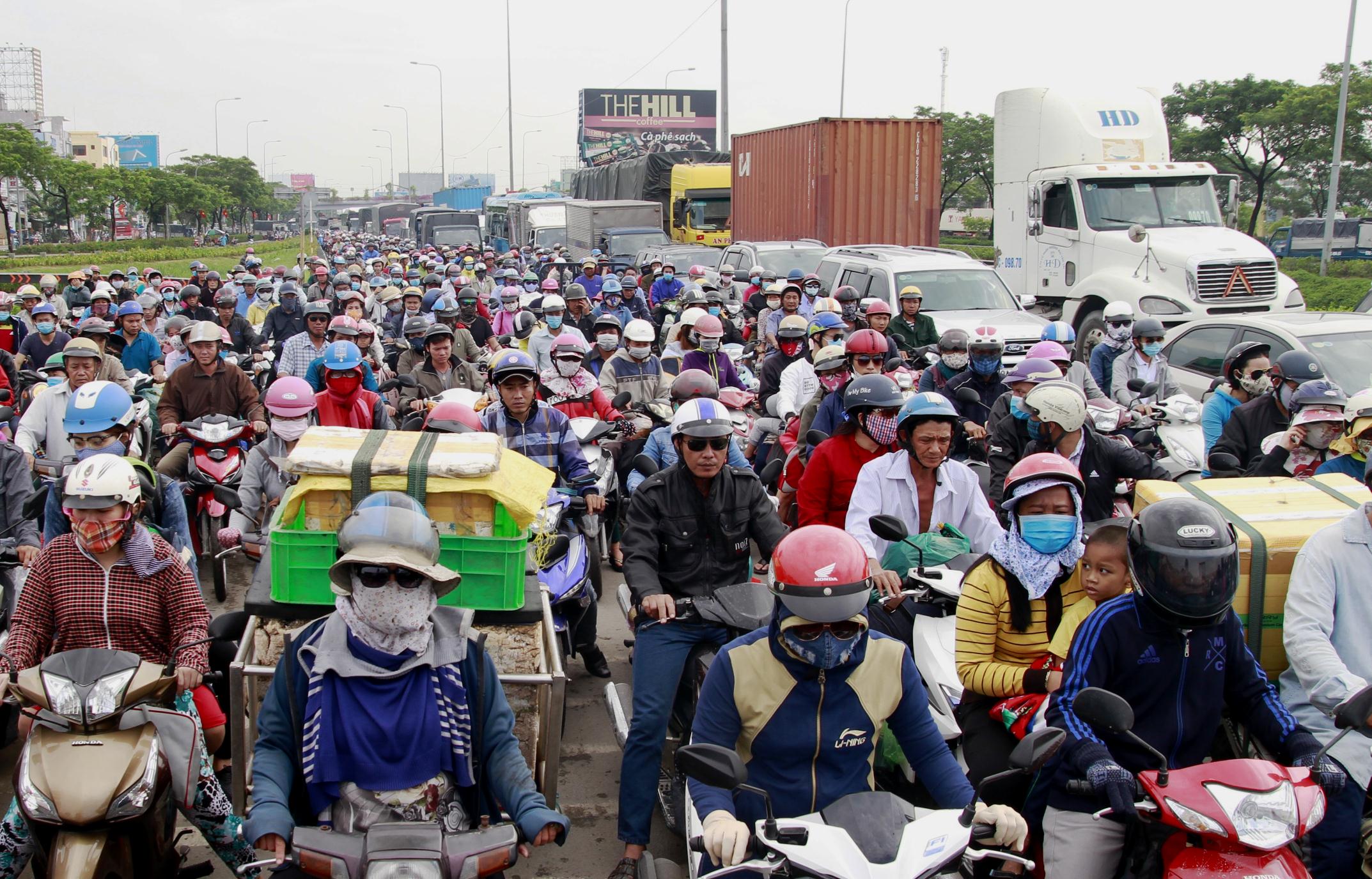 Qua ghi nhận của ph&oacute;ng vi&ecirc;n, đoạn Quốc lộ 1 k&eacute;o d&agrave;i từ v&ograve;ng xoay An Lạc (quận B&igrave;nh T&acirc;n) đến cầu B&igrave;nh Điền (huyện B&igrave;nh Ch&aacute;nh), c&aacute;c loại xe xếp ken đặc mặt đường. H&agrave;ng ng&agrave;n người đi xe m&aacute;y k&egrave;n cựa nhau, nh&iacute;ch từng ch&uacute;t để lưu th&ocirc;ng, trong khi d&ograve;ng &ocirc; t&ocirc; cũng như &ldquo;ch&ocirc;n ch&acirc;n&rdquo; tr&ecirc;n mặt đường