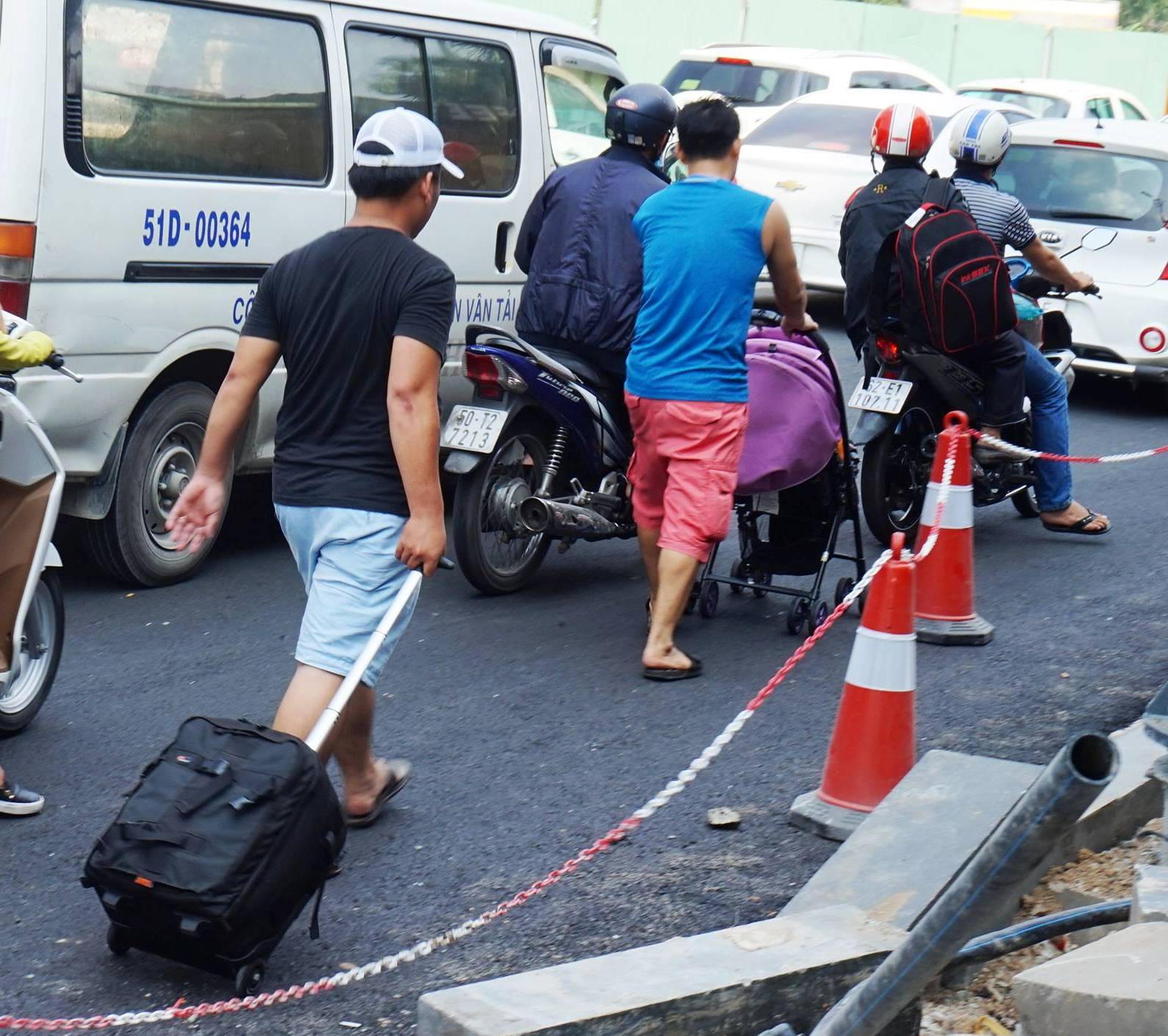 Nhiều người phải kéo hành lý đi bộ vào sân bay do sợ trễ giờ vì kẹt xe