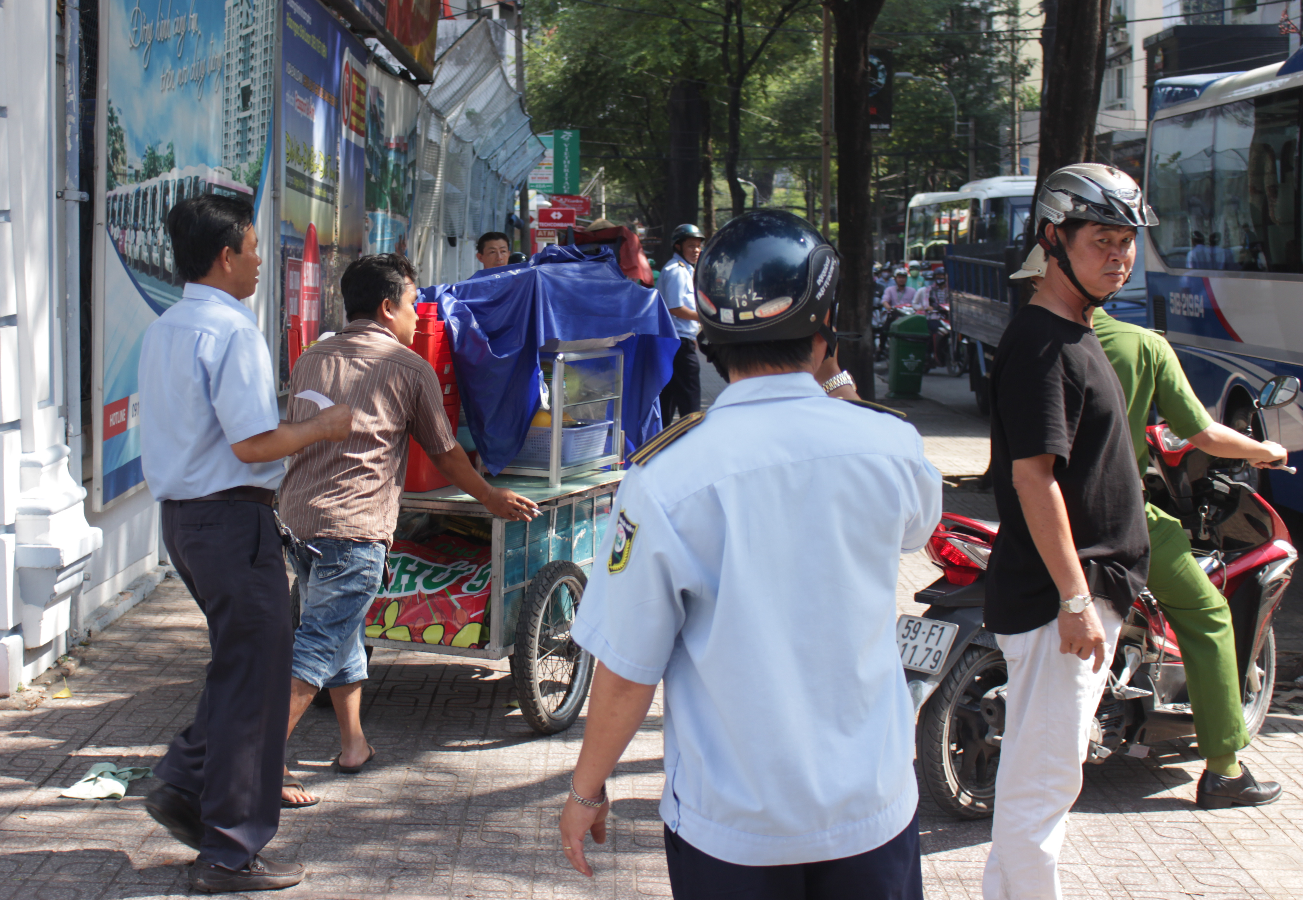 Lực lượng chức năng lập lại trật tự vỉa hè trên đường Võ Văn Tần.