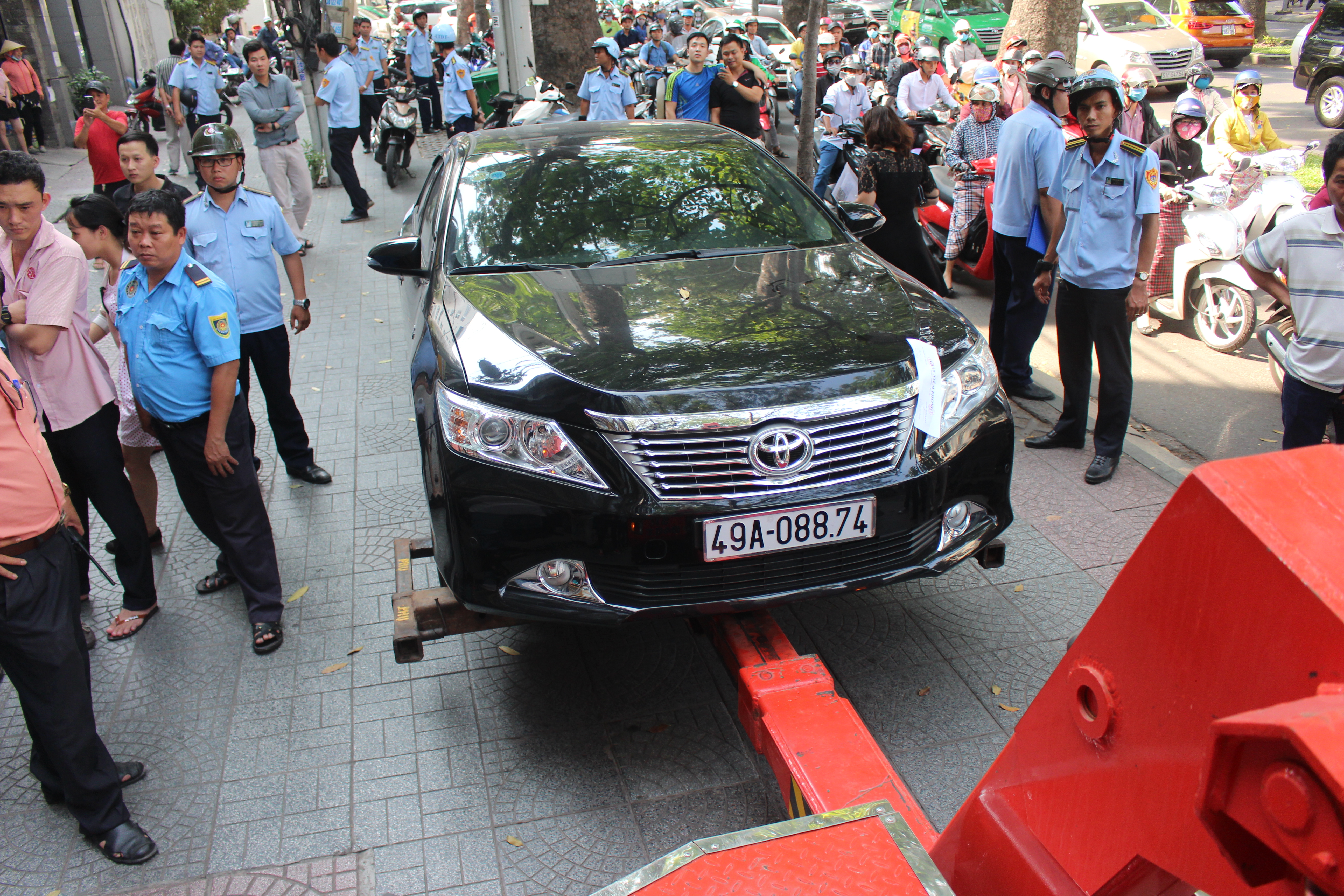
Chiếc xe Camry đậu tr&ecirc;n vỉa h&egrave; trước một ng&acirc;n h&agrave;ng tr&ecirc;n đường T&ocirc;n Đức Thắng bị ni&ecirc;m phong, cẩu về trụ sở cơ quan chức năng để xử l&yacute;.
