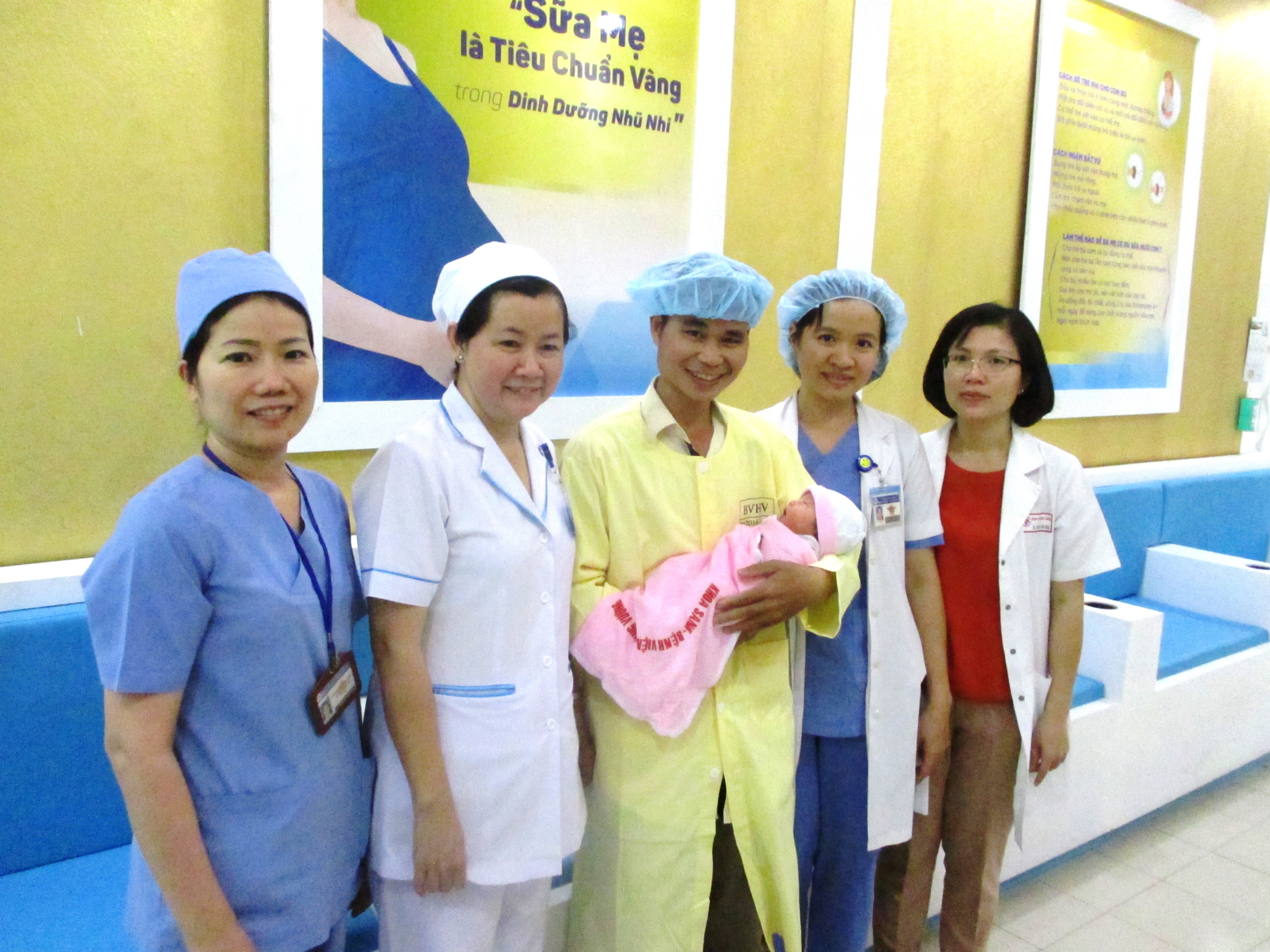 Chồng của chị S. vui vẻ chụp h&igrave;nh c&ugrave;ng c&aacute;c b&aacute;c sĩ, nữ hộ sinh của Bệnh viện H&ugrave;ng Vương khi được gặp con v&agrave; biết vợ đ&atilde; qua cơn nguy hiểm