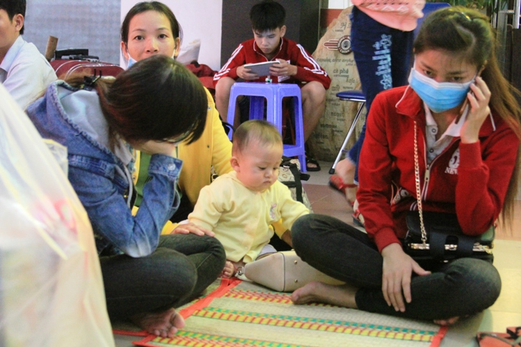 
M&ocirc;̣t em bé ng&ocirc;̀i chơi cùng người th&acirc;n trong nhà
