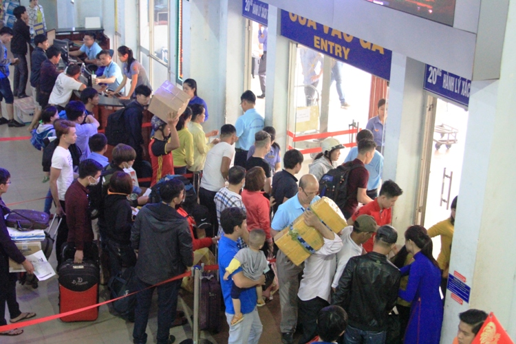 
Hành khách t&acirc;̣p trung ở cửa vào ga đ&ecirc;̉ l&ecirc;n tàu v&ecirc;̀ qu&ecirc; đón t&ecirc;́t
