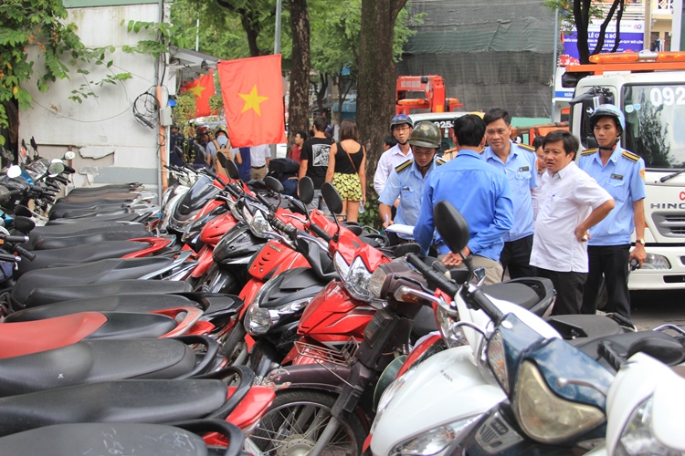 
B&atilde;i giữ xe dựng th&agrave;nh 2 h&agrave;ng tr&ecirc;n vỉa h&egrave; g&acirc;y kh&oacute; khăn cho người đi bộ bị lập bi&ecirc;n bản. &Ocirc;ng Hải cho biết nếu t&aacute;i phạm sẽ bị r&uacute;t giấy ph&eacute;p
