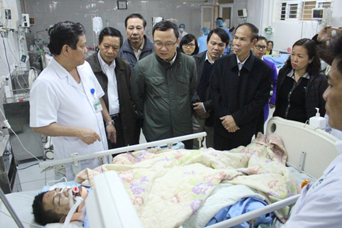 Ông Khuất Việt Hùng (áo xanh sẫm ở giữa) thăm hỏi các nạn nhân trong vụ tai nạn - Ảnh: Báo Lào Cai