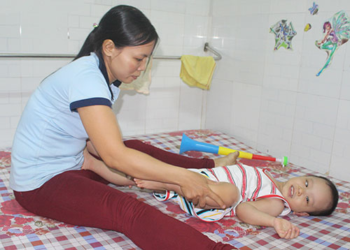 
Chị Nguyễn Thị Nga tập vật l&yacute; trị liệu cho con tại ph&ograve;ng trọ
