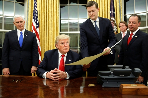Tân Tổng thống Mỹ Donald Trump đã ký những giấy tờ đầu tiên tại phòng Bầu dục. Ảnh: Reuters