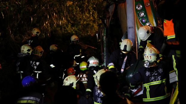 
Lực lượng cứu hộ cố gắng giải tho&aacute;t nạn nh&acirc;n trong xe. Ảnh: Reuters
