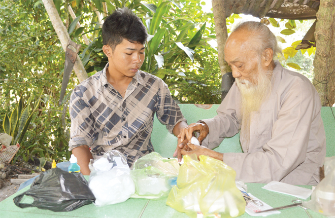 
&Ocirc;ng Tư Đền b&oacute; thuốc cho anh Chau Rit
