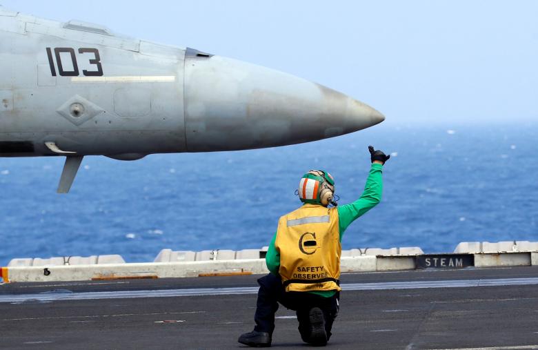 Ra tín hiệu bằng tay cho chiến đấu cơ F18 trên tàu sân bay USS Carl Vinson. Ảnh: Reuters