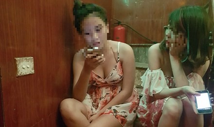 Hai cô gái làm tay vịn cho một quán hát ở quận Thanh Xuân, Hà Nội ngồi chờ khách