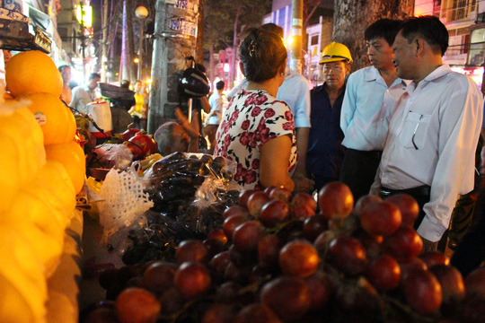 
&Ocirc;ng Mỹ l&agrave;m việc với 1 hộ b&aacute;n tr&aacute;i c&acirc;y lấn chiếm vỉa h&egrave; tr&ecirc;n đường Nguyễn Tri Phương.
