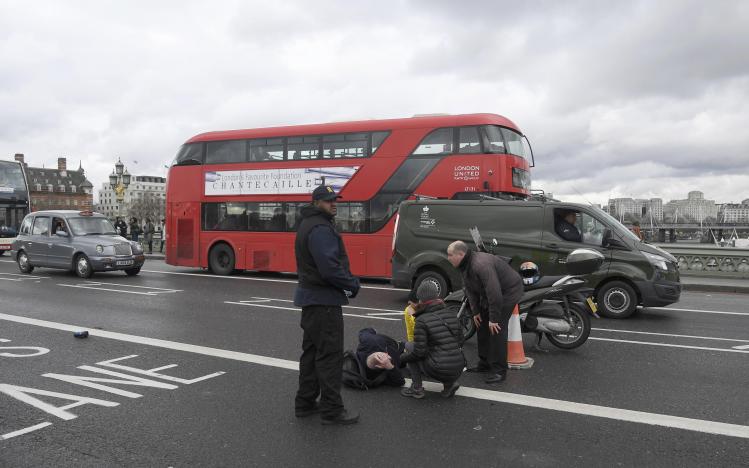 
Một người đ&agrave;n &ocirc;ng bị thương đang nằm tr&ecirc;n cầu Westminster, London sau vụ xả s&uacute;ng. Ảnh: Reuters
