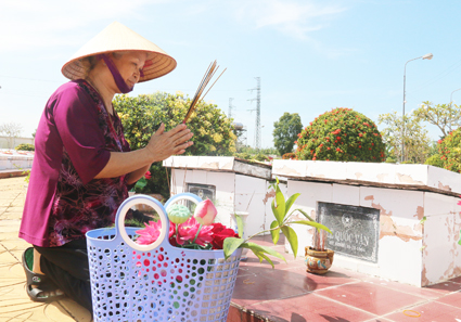 Bà Loan viếng mộ con trai ở Nghĩa trang Liệt sĩ quận Ô Môn. Ảnh: DUY KHÔI
