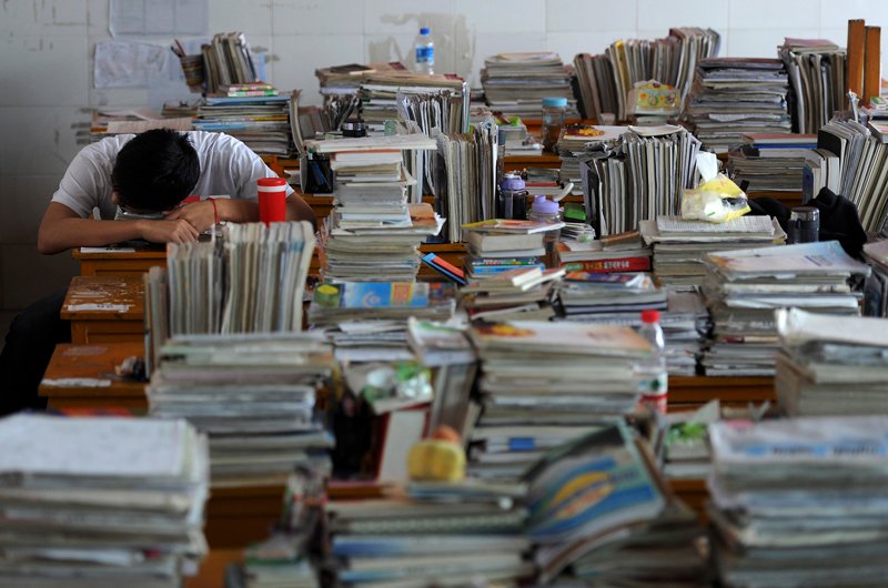 
Một học sinh ở TP Hợp Ph&igrave; gục b&ecirc;n s&aacute;ch vở khi học &ocirc;n thi đại học. Ảnh: REUTERS
