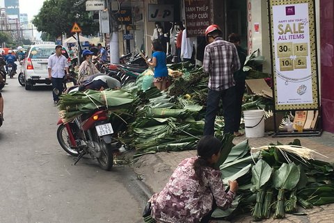 Lá dong được đổ đống trên lề đường Cách Mạng Tháng 8. Ảnh: Trần Chánh Nghĩa