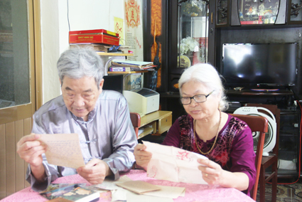 Ông bà An Ninh bồi hồi bên kỷ vật con trai- Liệt sĩ Lê Văn. Ảnh: DUY KHÔI