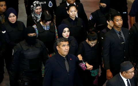 Hai bị cáo bị áp giải tại sân bay hôm 24-10. Ảnh: Reuters