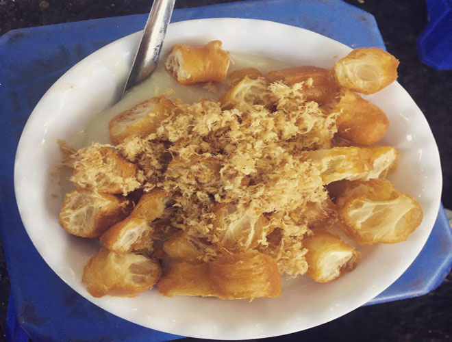 
Ch&aacute;o sườn sụn thường mở từ l&uacute;c 5h chiều, c&agrave;ng về đ&ecirc;m c&agrave;ng đ&ocirc;ng kh&aacute;ch. Ch&aacute;o ở đ&acirc;y được ninh nhừ, nhuyễn như bột, đặc s&aacute;nh, thơm m&ugrave;i thịt v&agrave; ngọt vị nước hầm xương. Ch&aacute;o thường được ăn k&egrave;m với quẩy n&oacute;ng v&agrave; ruốc cho hương vị đậm đ&agrave; hơn. Gi&aacute; một b&aacute;t ch&aacute;o sườn sụn l&agrave; 30.000 đồng, c&oacute; k&egrave;m th&ecirc;m quẩy l&agrave; 35.000 đồng. Ảnh: Chinh L&ecirc;
