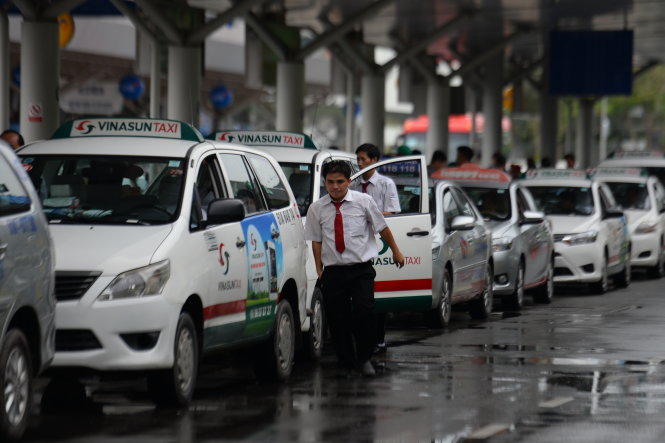 T&agrave;i xế taxi xếp h&agrave;ng v&agrave;o đ&oacute;n kh&aacute;ch ở s&acirc;n bay T&acirc;n Sơn Nhất - Ảnh: HỮU KHOA