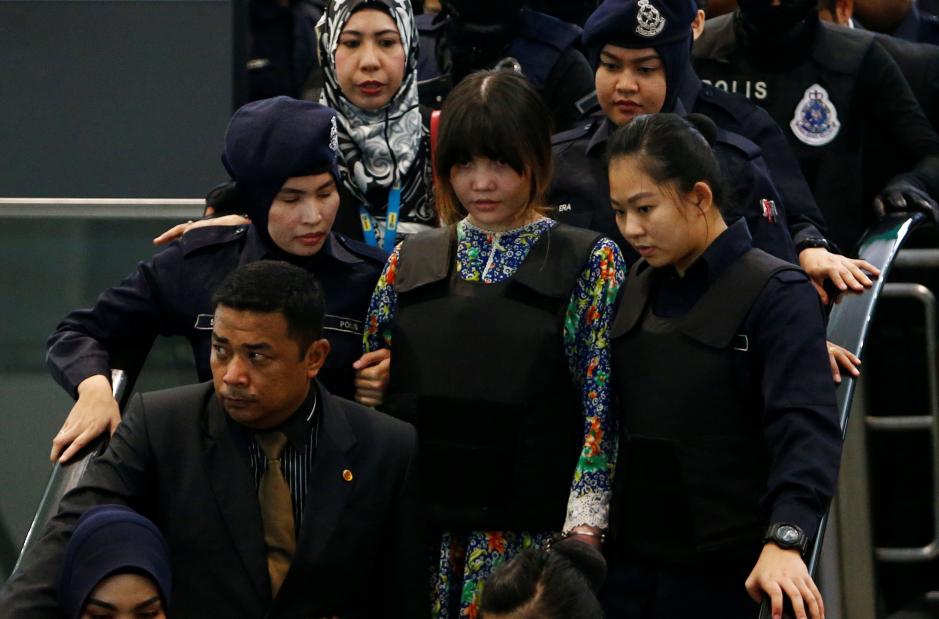Đoàn Thị Hương (áo hoa) mặc áo chống đạn. Ảnh: Reuters