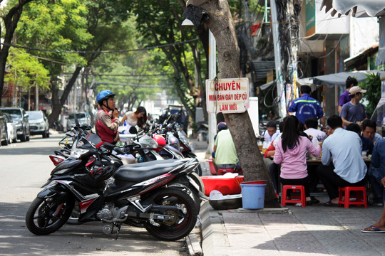 Tr&ecirc;n đường L&ecirc; Thị Hồng Gấm, một qu&aacute;n ăn chiếm dụng vỉa h&egrave; l&agrave;m nơi đặt b&agrave;n ghế, l&ograve;ng đường cũng ngang nhi&ecirc;n được l&agrave;m nơi giữ xe cho kh&aacute;ch.