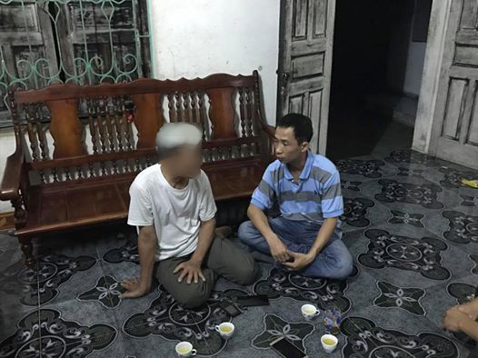 Phóng viên Văn Duẩn của Báo Người Lao Động (phải) đang trò chuyện với một người dân xã Đồng Tâm vào tối ngày 19-4