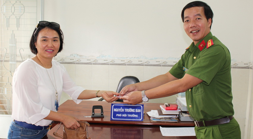 Thiếu tá công an ngồi lề đường chờ người nhận lại của rơi