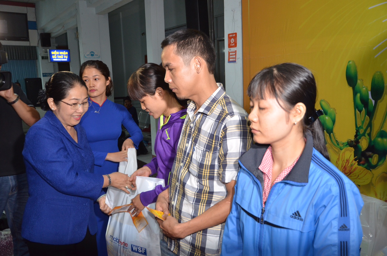 Bà Võ Thị Dung, Phó Bí thư Thành ủy TP HCM, tặng quà cho các công nhân được nhận vé tàu