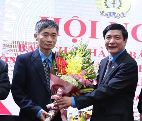 Ông Trần Văn Thuật (trái) nhận hoa chúc mừng của Chủ tịch Tổng LĐLĐ Việt Nam Bùi Văn Cường