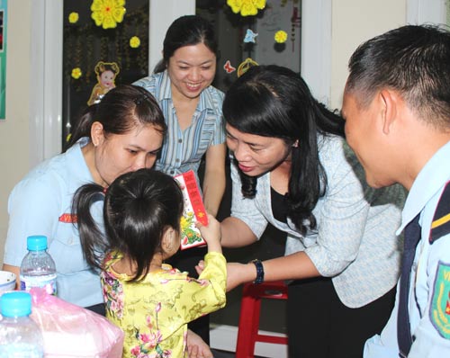 Bà Trần Kim Yến, Chủ tịch LĐLĐ TP HCM, lì xì cho con công nhân Ảnh: THANH NGA
