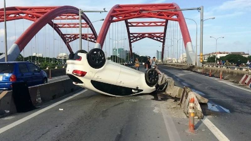 Hai người k&ecirc;u cứu trong chiếc xế hộp lật ở cầu &Ocirc;ng Lớn - Ảnh 1.