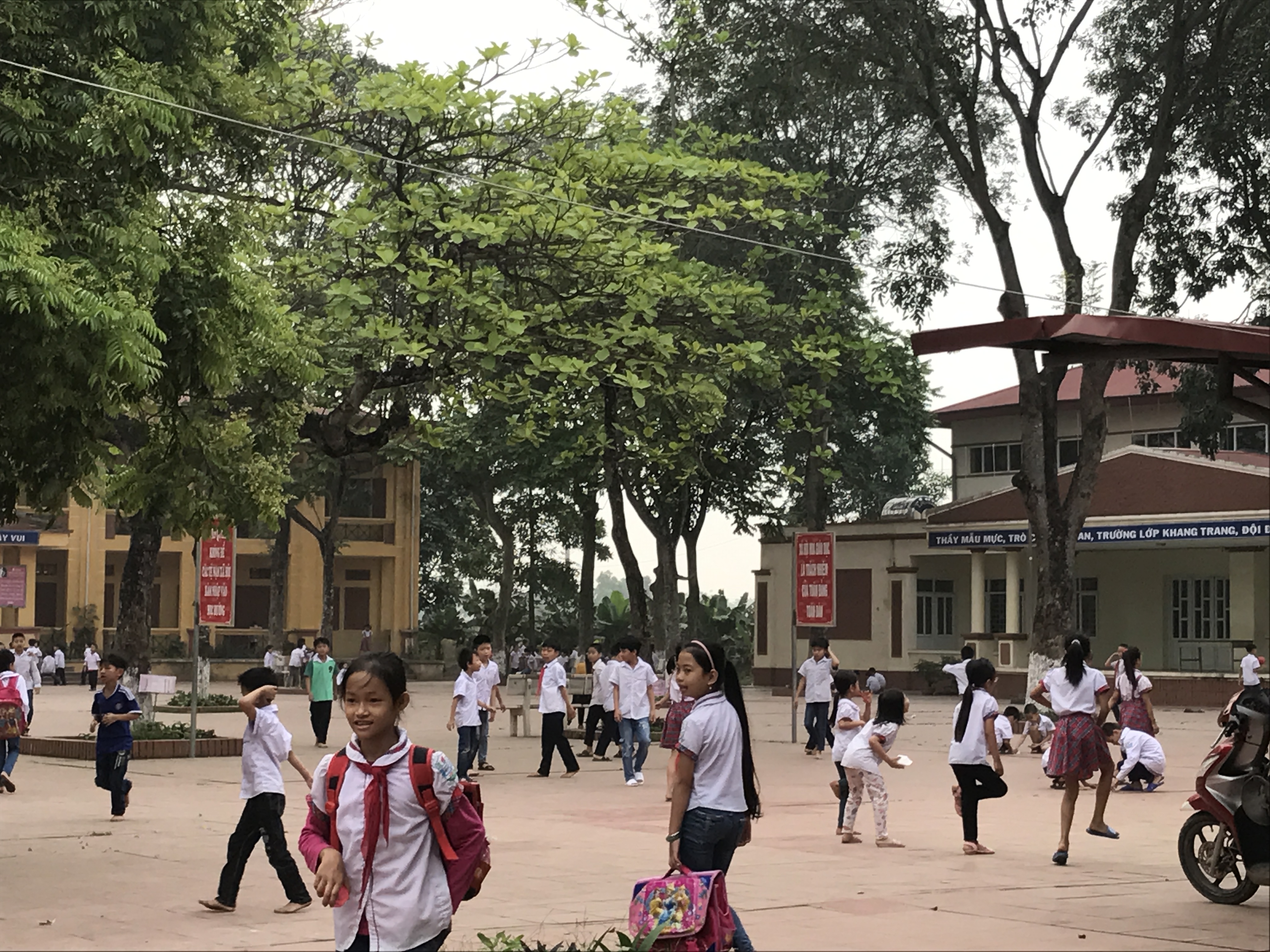 Học sinh đùa nghịch trong sân trường trước giờ học