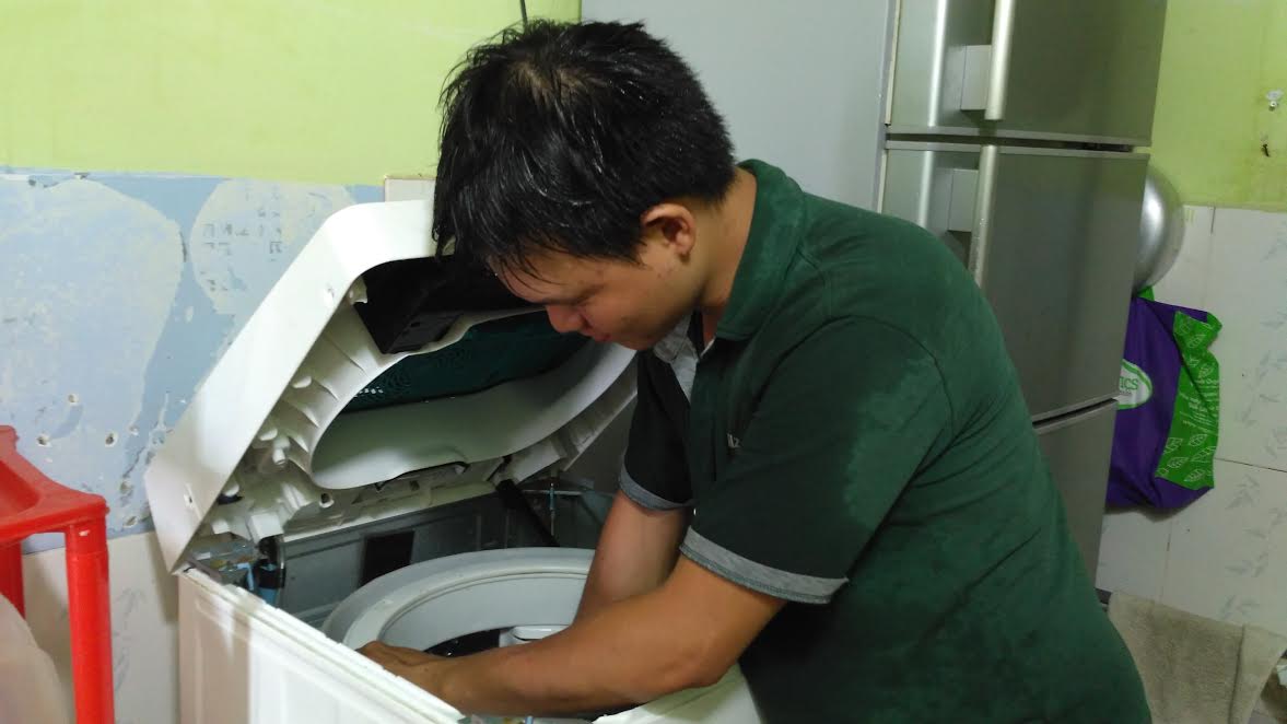 Thợ điện lạnh mướt mồ hôi kiếm tiền triệu từ việc vệ sinh máy giặt, tủ lạnh. Ảnh: Ngọc Ánh