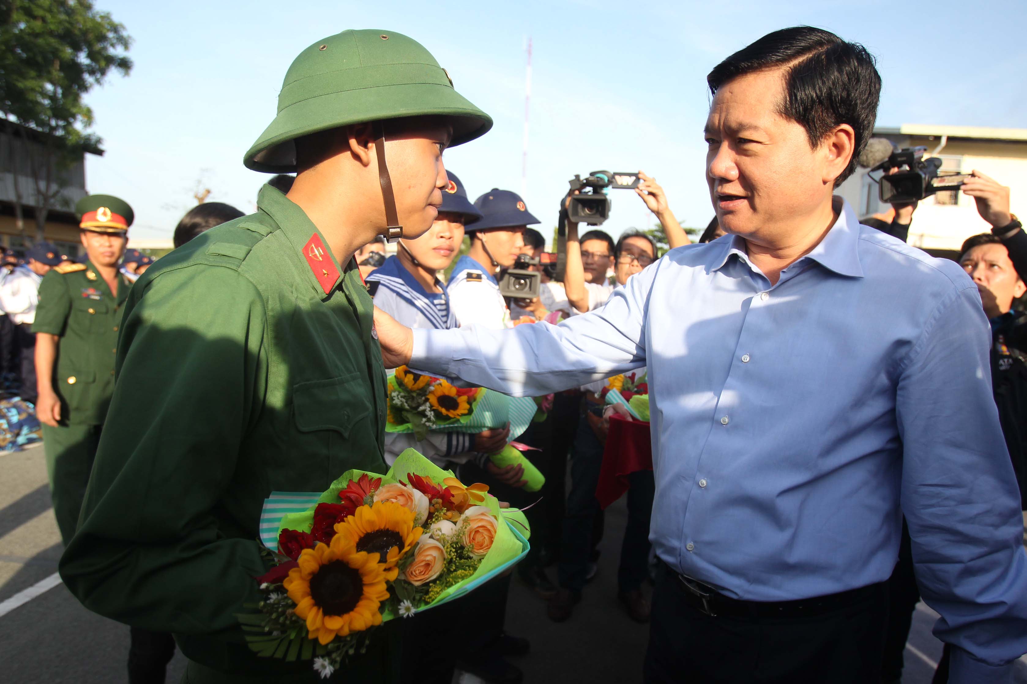 Bí thư Thành ủy TP HCM Đinh La Thăng tặng hoa, thăm hỏi, động viên các tân binh trước giờ lên đường làm nhiệm vụ.