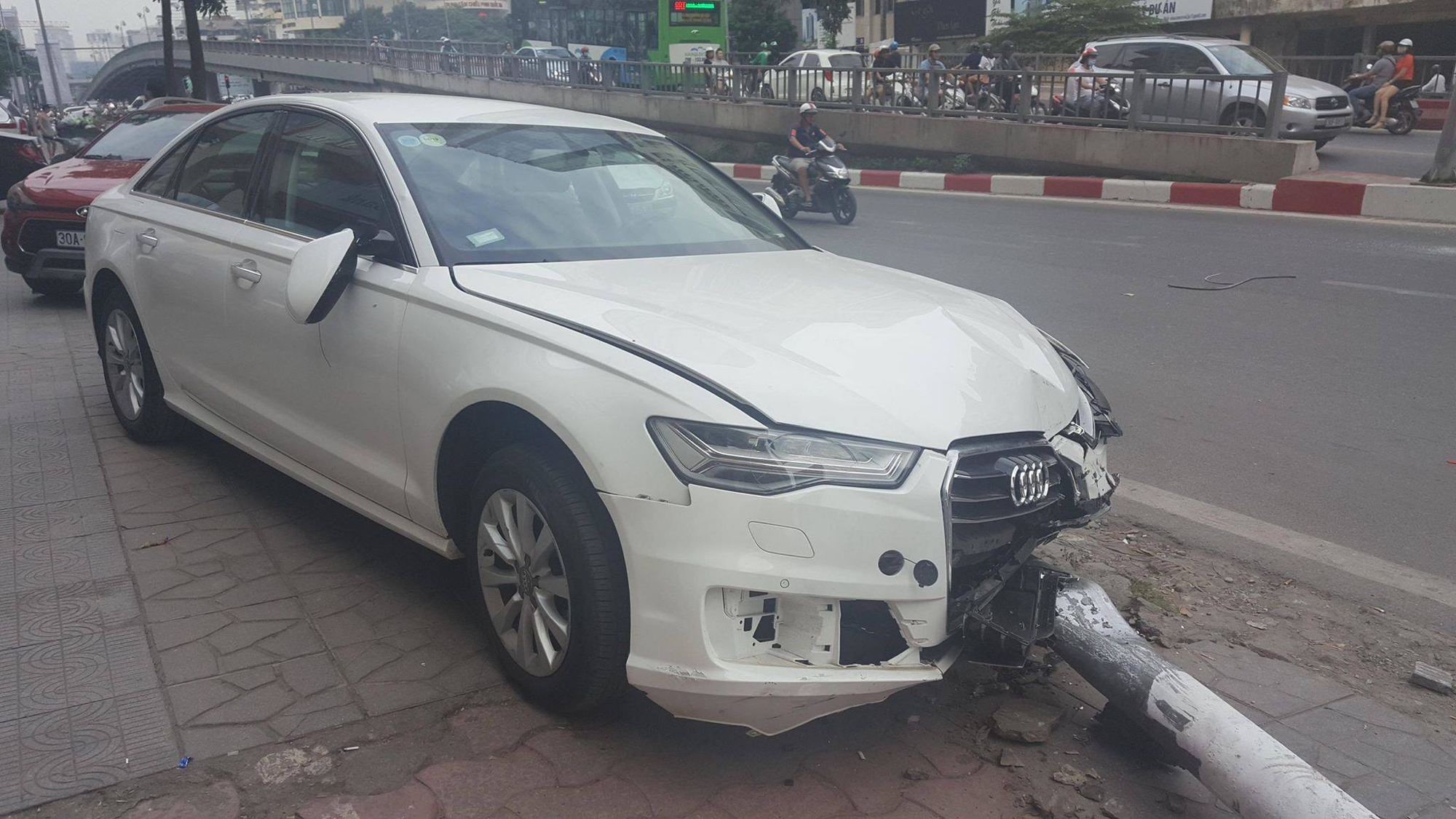 Xế hộp Audi lao lên vỉa hè tông cột đèn đổ trúng đầu người đi đường