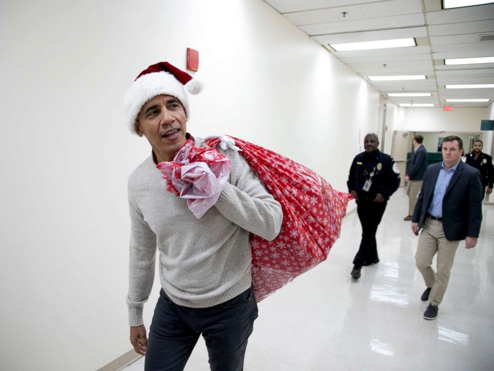 “Ông già Noel” Obama đội mũ đỏ, khệ nệ vác túi quà to