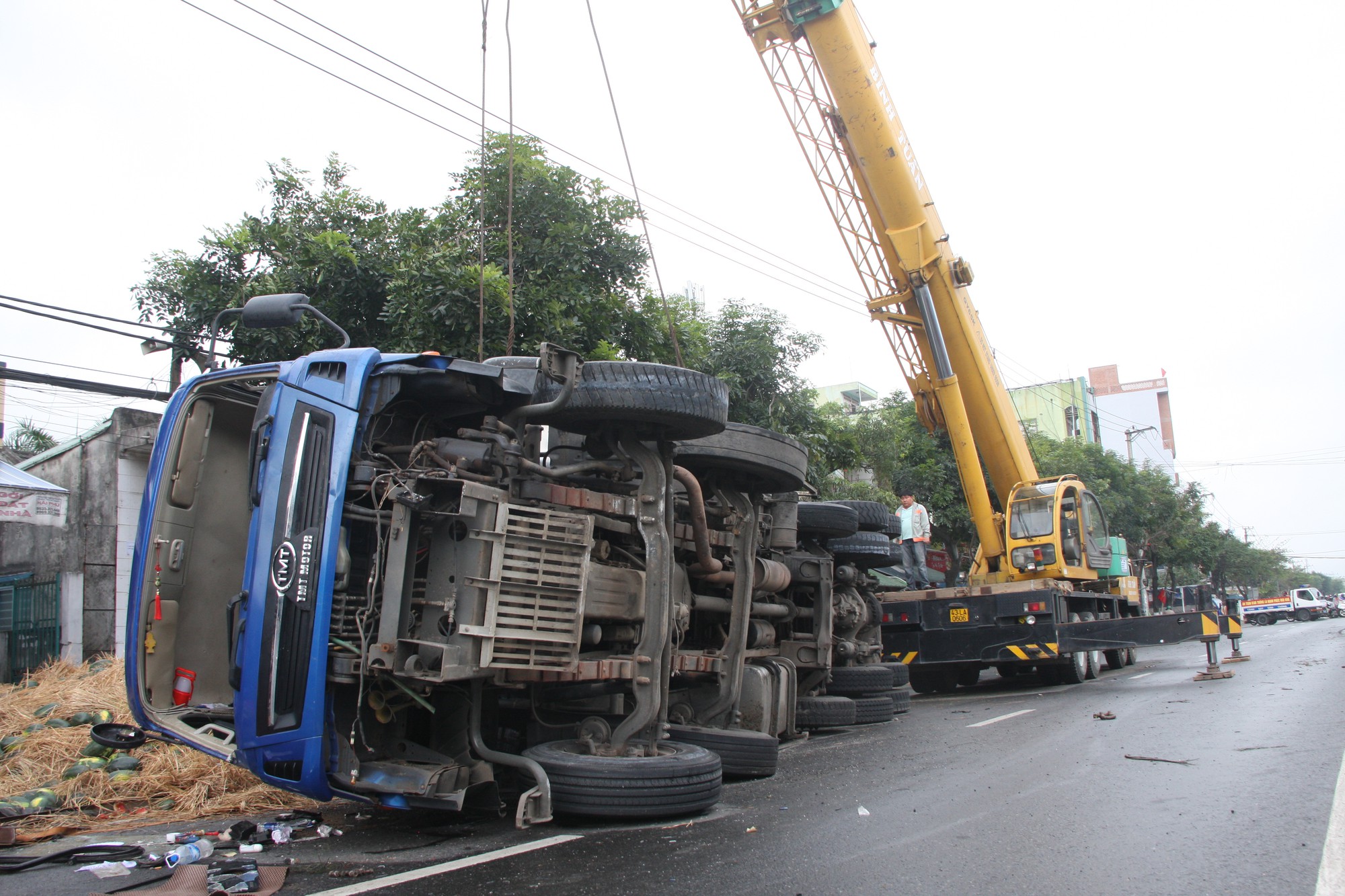 Tài xế ngủ gật, xe tải chở dưa lật nhào ra đường