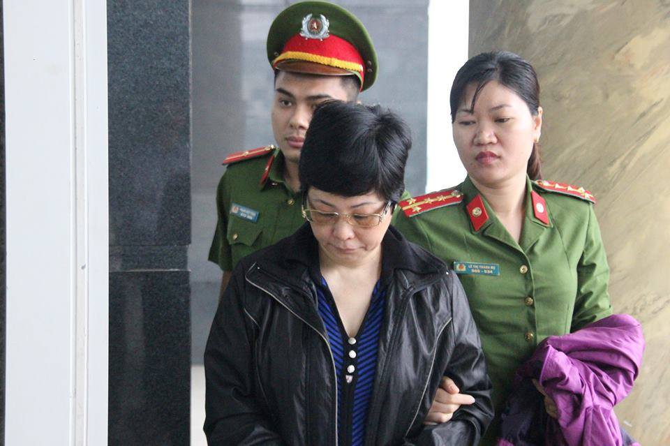 Bà Châu Thị Thu Nga mặc áo khoác đen, né ống kính phóng viên ra tòa phúc thẩm
