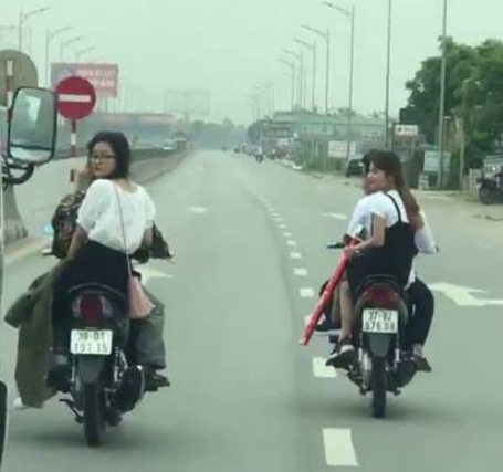 Nam nữ thanh niên “đầu trần” chạy xe máy hàng ngang, đánh võng trên QL1A - Ảnh 1.