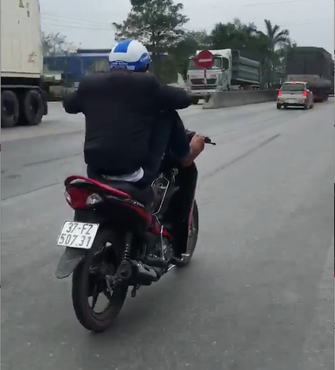 Clip nam thanh niên dùng chân điều khiển xe máy “làm xiếc” trên quốc lộ - Ảnh 1.