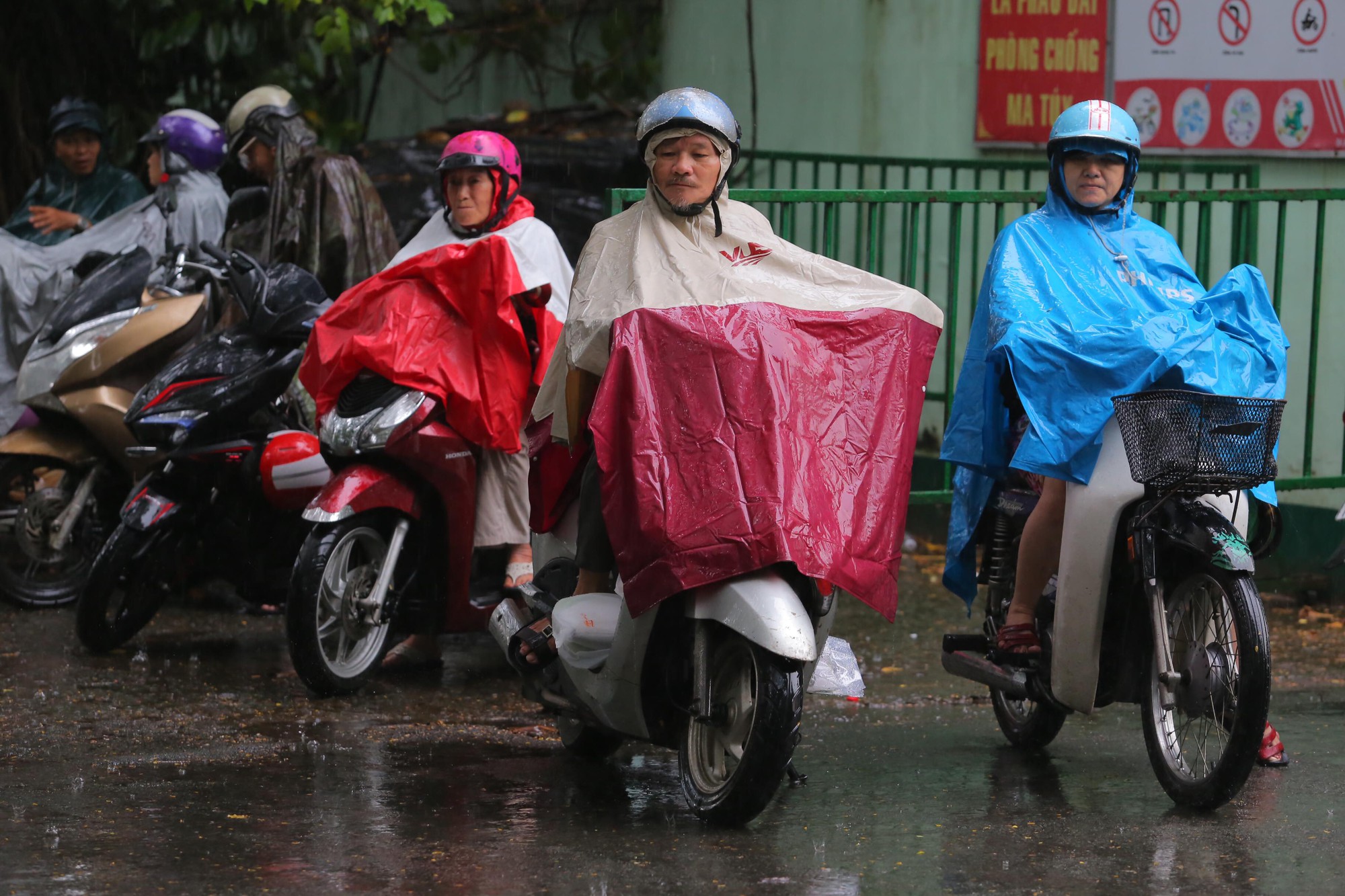 Phụ huynh chờ con thi THPT trong cơn mưa chiều tầm t&atilde; - Ảnh 1.