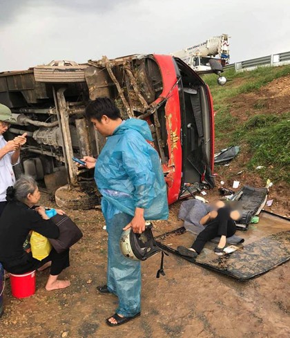 Hành khách hoảng sợ khi xe khách lao khỏi đường cao tốc, lật nghiêng - Ảnh 1.